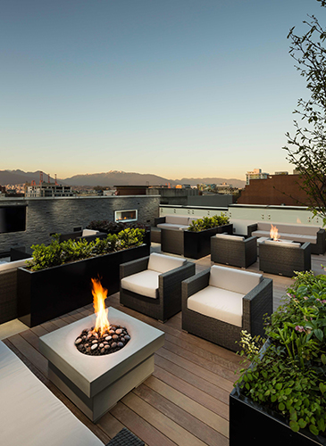 Fire pit and rooftop lounge looks out at the North Shore Mountains from BLUESKY Chinatown by Bosa Properties