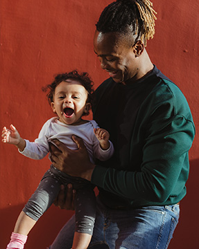 Man holding child laughing